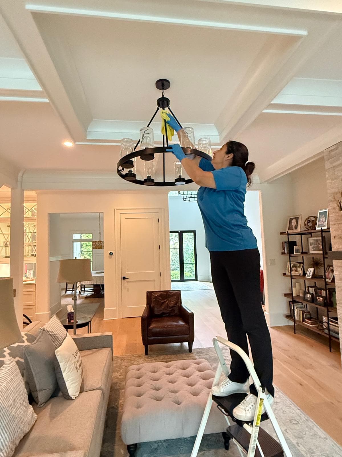 Team member cleaning a living room chandelier