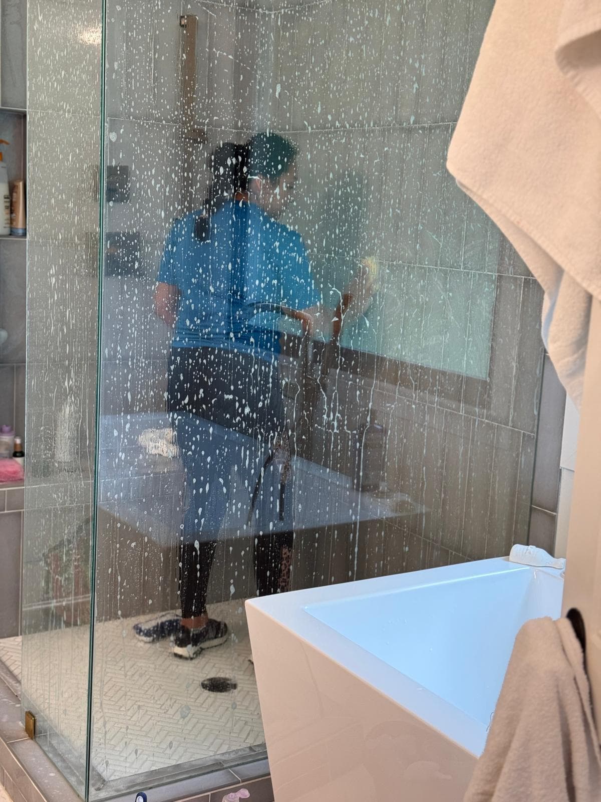 Team member cleaning glass shower walls