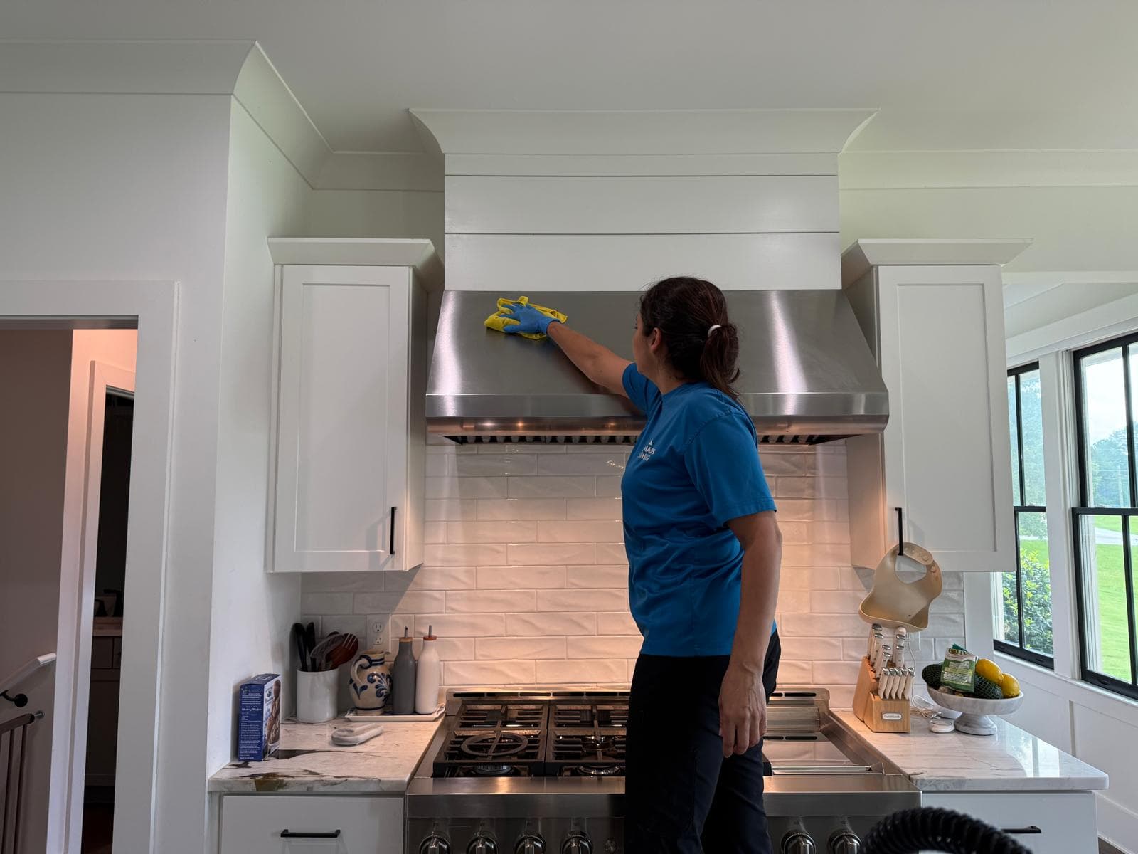 Team member cleaning a stainless steel range hood